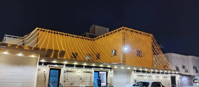 واجهة مبنى مزينة بسلاسل إنارة ذهبية متدلية في المساء