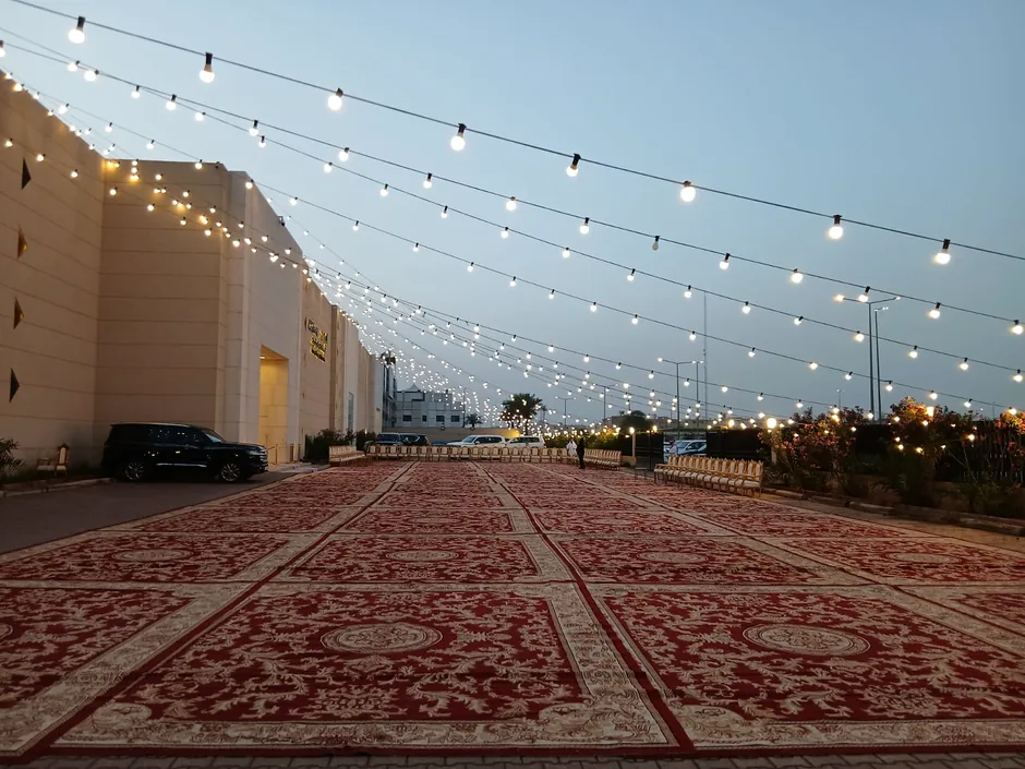 موقع خارجي واسع مفروش بالسجاد ومزين بسلاسل الإضاءة