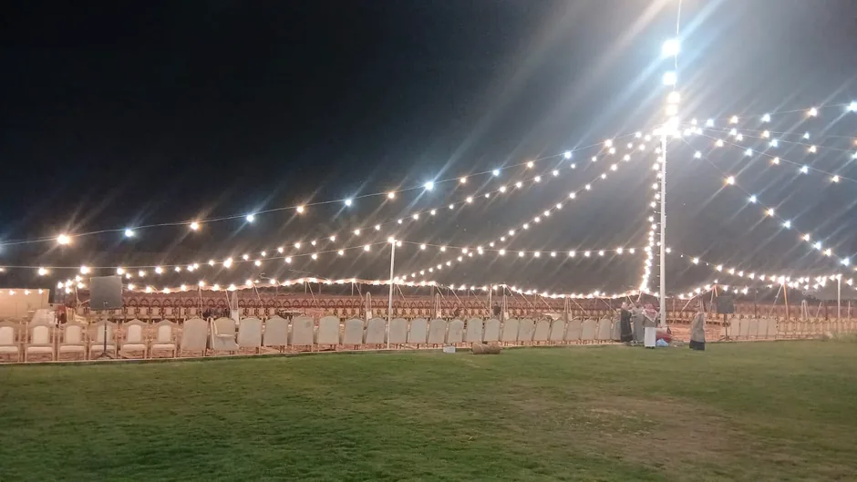 سلاسل إضاءة ليلية فوق مساحة خارجية مفروشة بالعشب